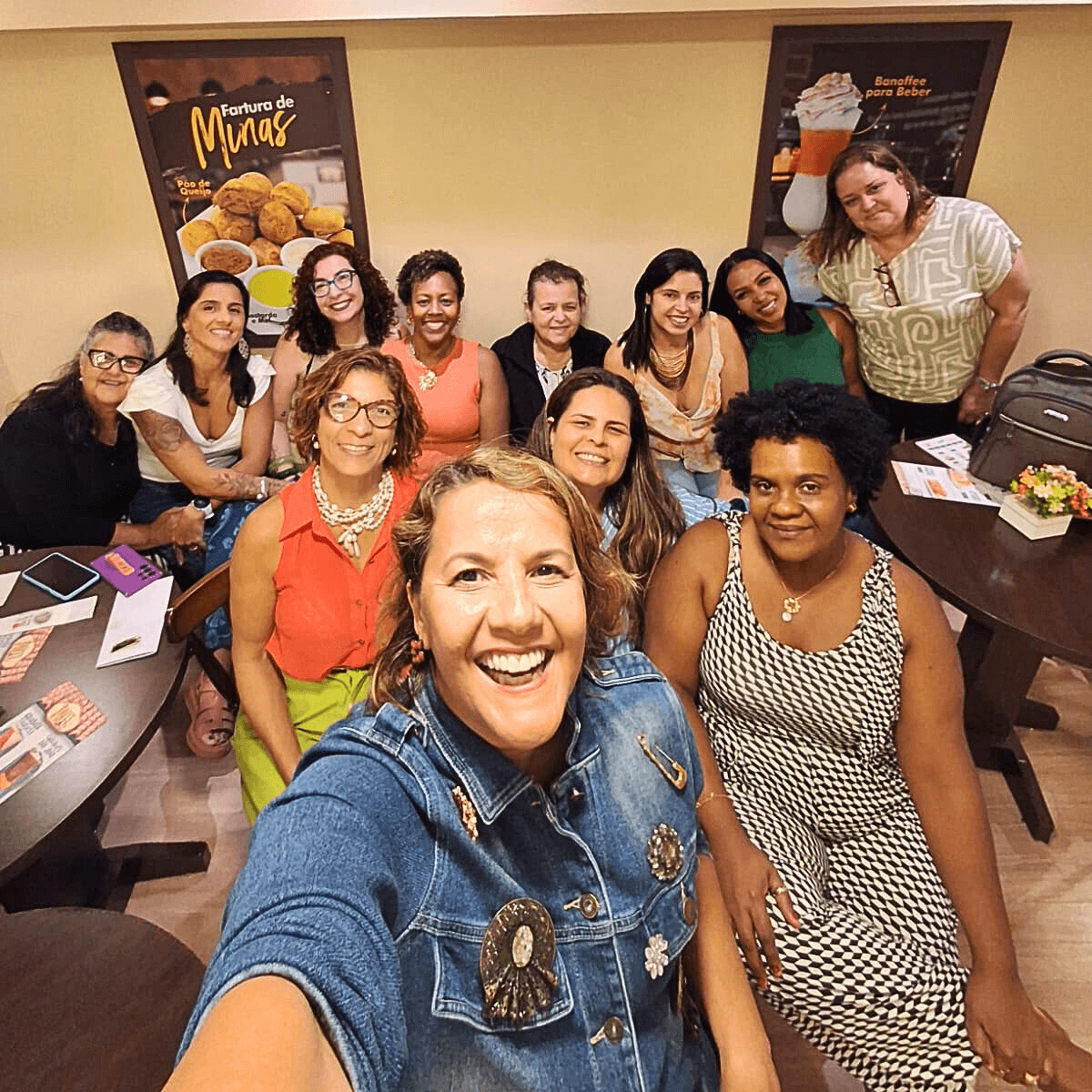 Grande grupo de mulheres posando para uma foto coletiva em um evento.