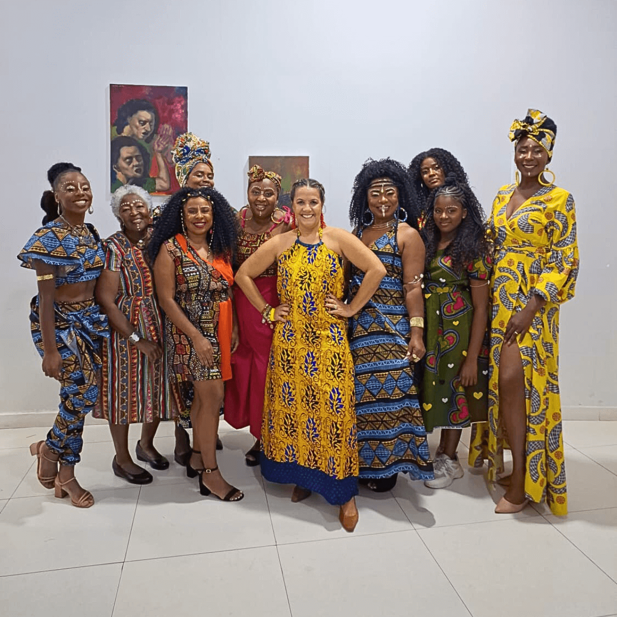 Grupo de mulheres, muitas com roupas estampadas e coloridas, posando para uma foto.
