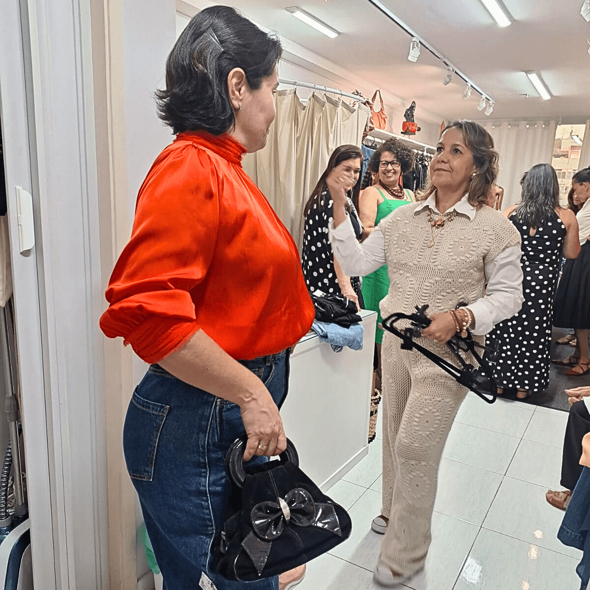 Duas mulheres em pé lado a lado, olhando para algo fora do enquadramento.